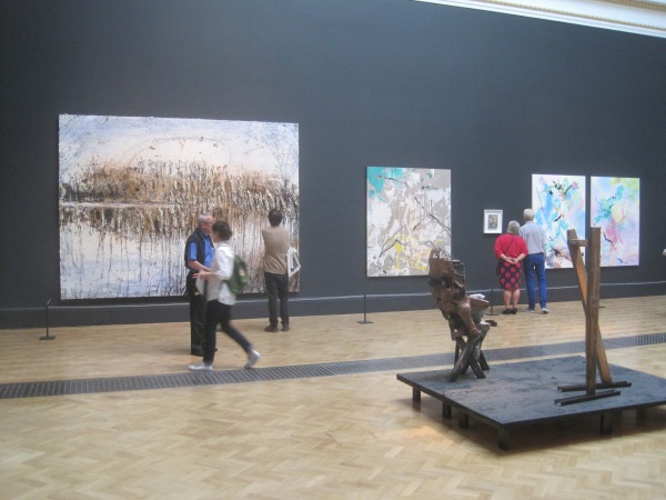 View of the Lecture Room including, from left to right, Und Du Bist Maler Geworden by Anselm Kiefer, Painting For B by Secundino Hernández, and She Pricked Her Finger Cutting the Clouds and Many-Coloured Messenger Seeks Her Fortune by Fiona Rae RA