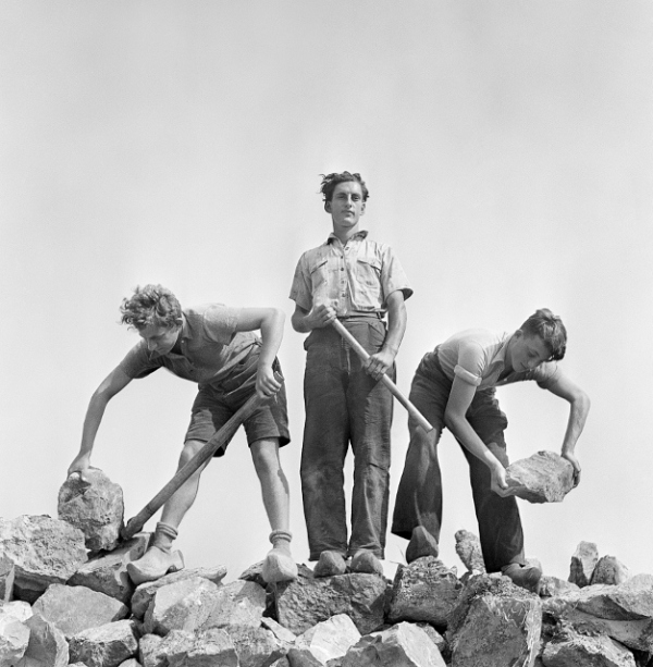 Ernst Kaufmann, center, and unidentified Zionist youth, wearing clogs while learning construction techniques in a quarry, Werkdorp Nieuwesluis, Wieringermeer, The Netherlands (1938–39) by Roman Vishniac © Mara Vishniac Kohn